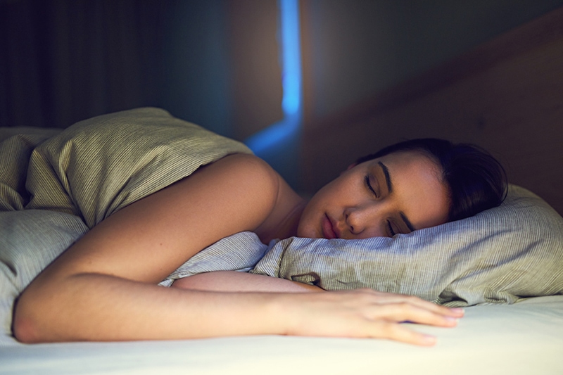 Blog Title: 3 Health Benefits for Using Your AC While Sleeping Photo: Person getting a good night sleep