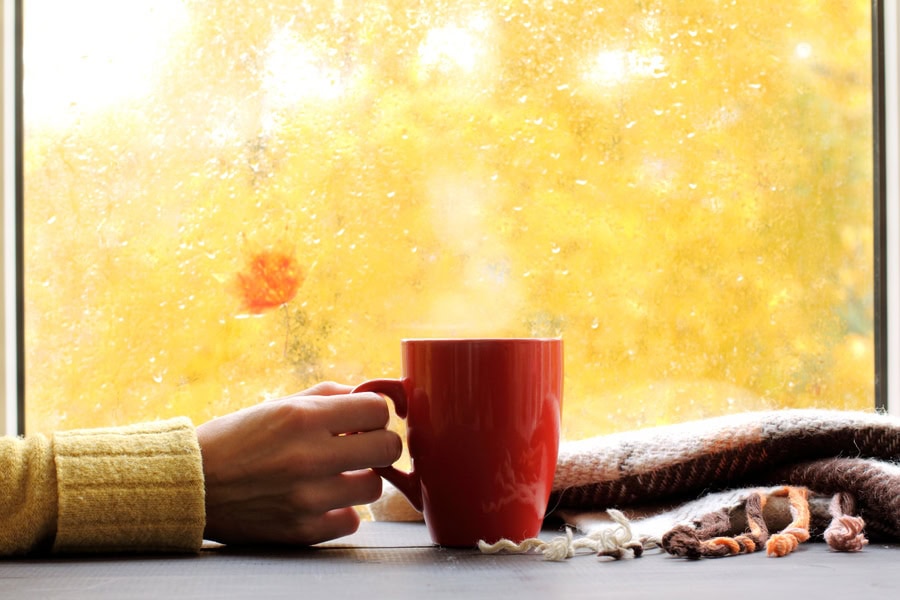 red mug of hot drink, when behind a window is rain in autumn in Beaverton, OR