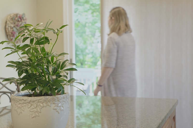 Lady standing by an open door in her house